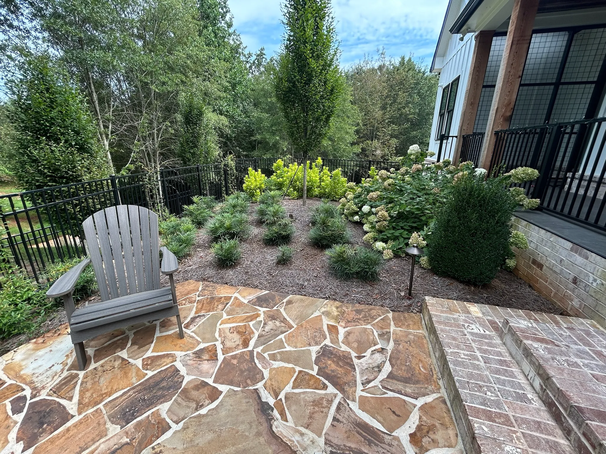 Expert local landscaping in Braselton showcasing a luxury backyard design with permeable stone walkways and native pollinator gardens compliant with Chateau Elan area aesthetic standards.