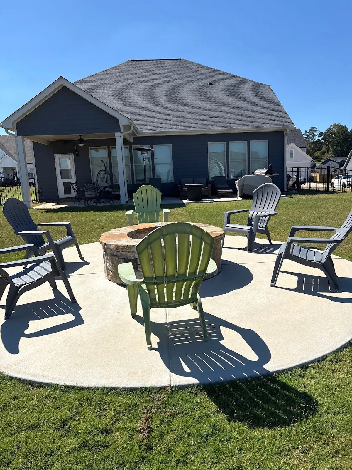 A concrete fire pit patio with lawn chairs shows landscape design & installation in Watkinsville, GA.