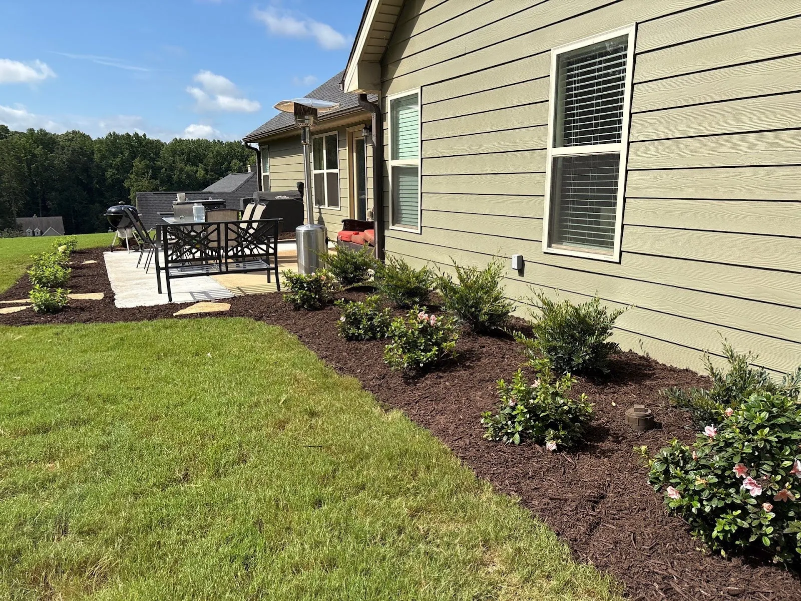Freshly mulched garden beds and patio showcase landscape design & installation in Hoschton, GA.